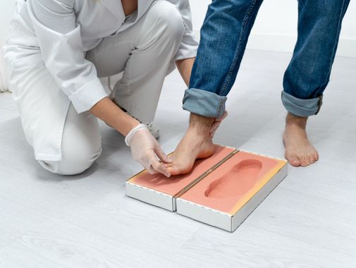 podóloga haciendo moldes de los pies de un paciente para analizar su pisada